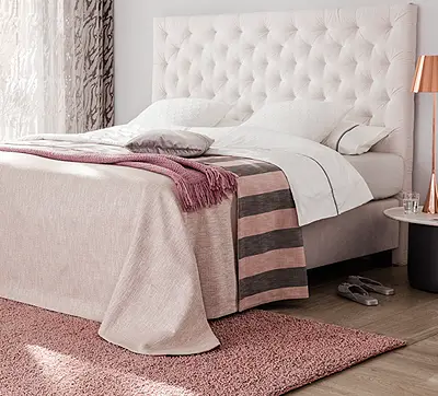 Schlafzimmer mit rosafarbenem Schurwollteppich von JAB Anstoetz