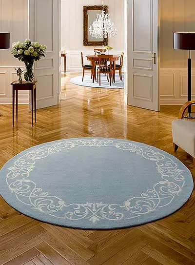 Fischgrät-Parkett und runder Teppich mit Lilienmuster in elegantem Ambiente